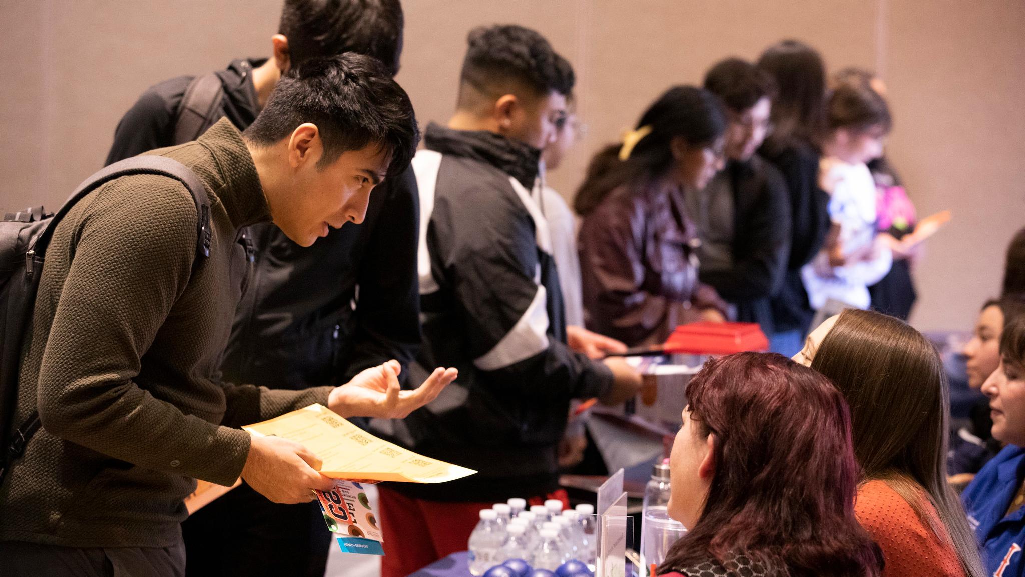 Student receiving information at first-gen resource fair